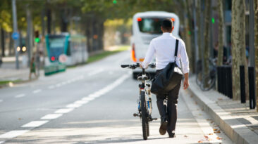 businessman-walking-with-bike-in-street-after-work_1262-5982