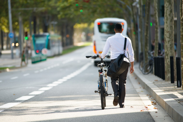 businessman-walking-with-bike-in-street-after-work_1262-5982
