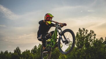 Aerial jump with a downhill bike during sunset through sand skatepark. Zaragoza, Spain.