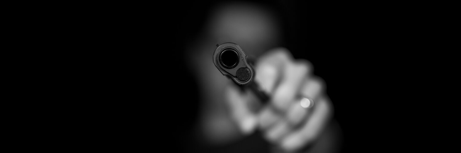 grayscale photography ofperson holding gun